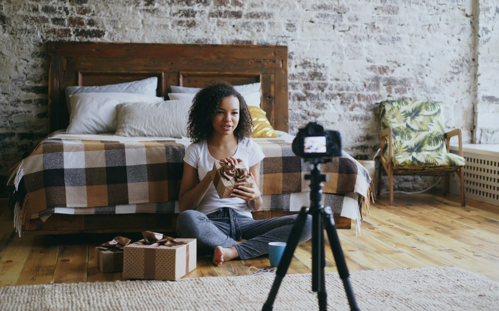 Mulher gravando um vídeo em casa com a câmera apoiada em um tripé